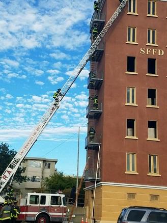 Recruit Training - image of active drill with aerial ladder extended to training tower