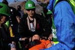 NERT volunteer in green helmet stabilizes the head of a mannequin in a skills exercise.