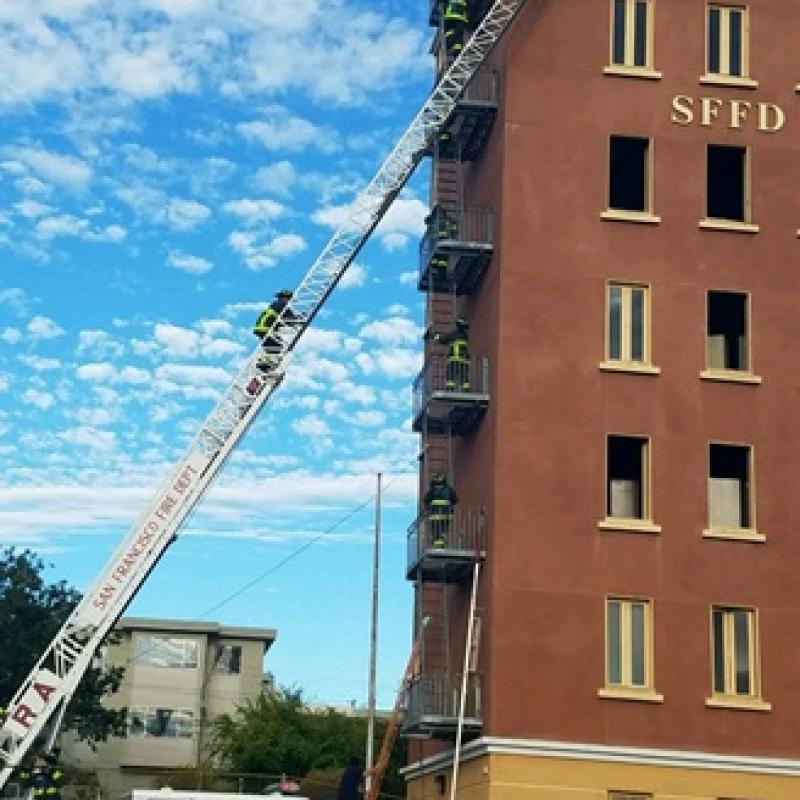 Recruit Training - image of active drill with aerial ladder extended to training tower